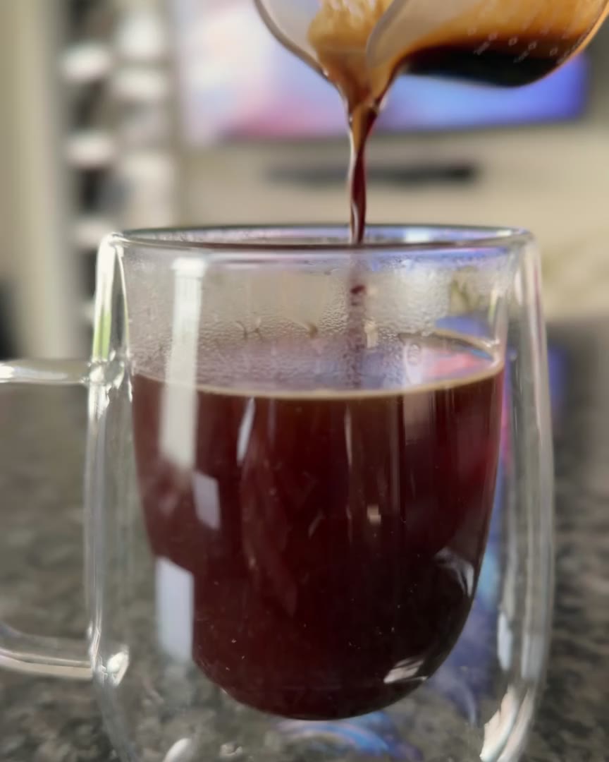 Espresso blooming into a glass cup